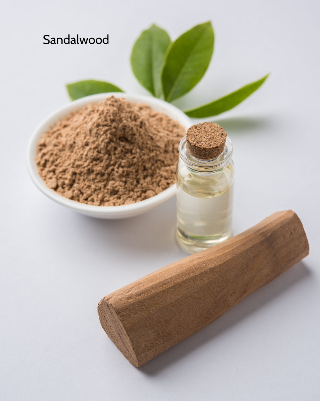sandalwood powder in a small dish next to a dram jar, and apiece of smooth sandalwood