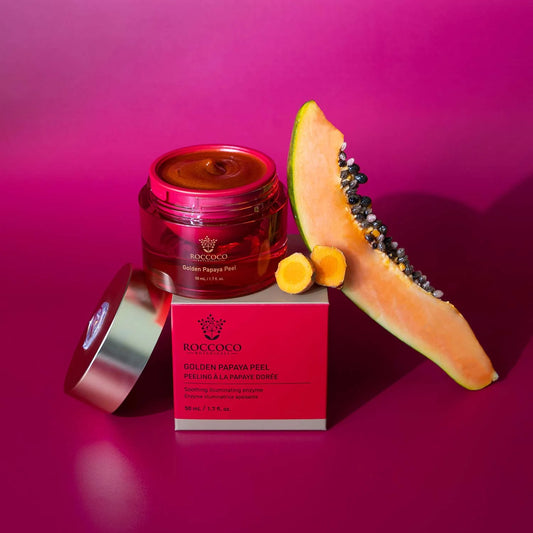Roccoco Golden Papaya Peel with a sliced papaya on a pink background